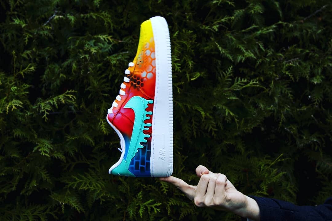 Unique custom Air Force 1s showcasing a color gradient from yellow to blue, accented with hexed patterns and a blue-dripping Nike swoosh.