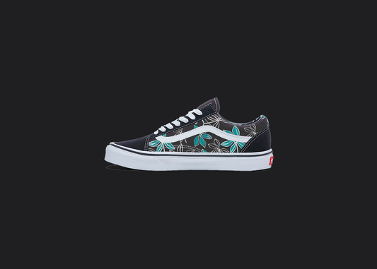 The image is featuring a custom hand painted floral shoes on a blank black background. The vans old skools sneaker has a blue floral print design on the side of shoes. 