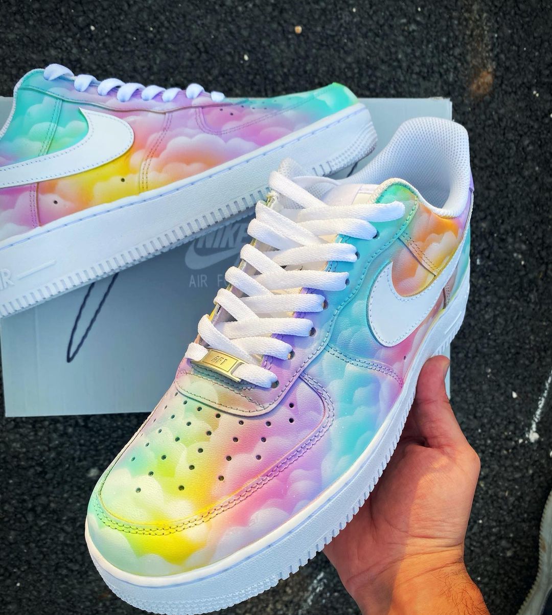 Close-up of custom Air Force 1 with handpainted pastel clouds and soft rainbow hues, showcasing the white swoosh and lace details.