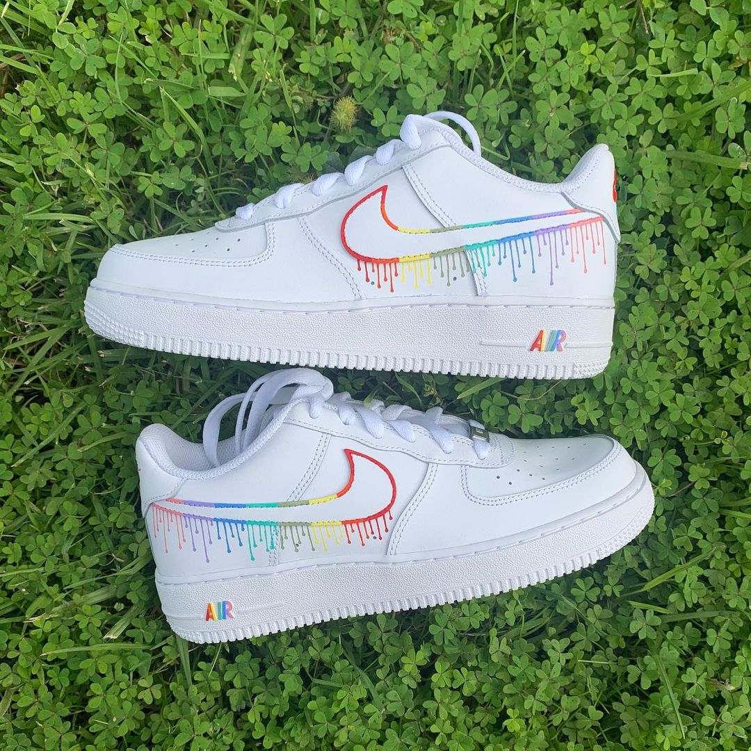 pair of nike air force 1s with a colorful dripping design on the nike swoosh, sole and on the back heel panel. Grass background