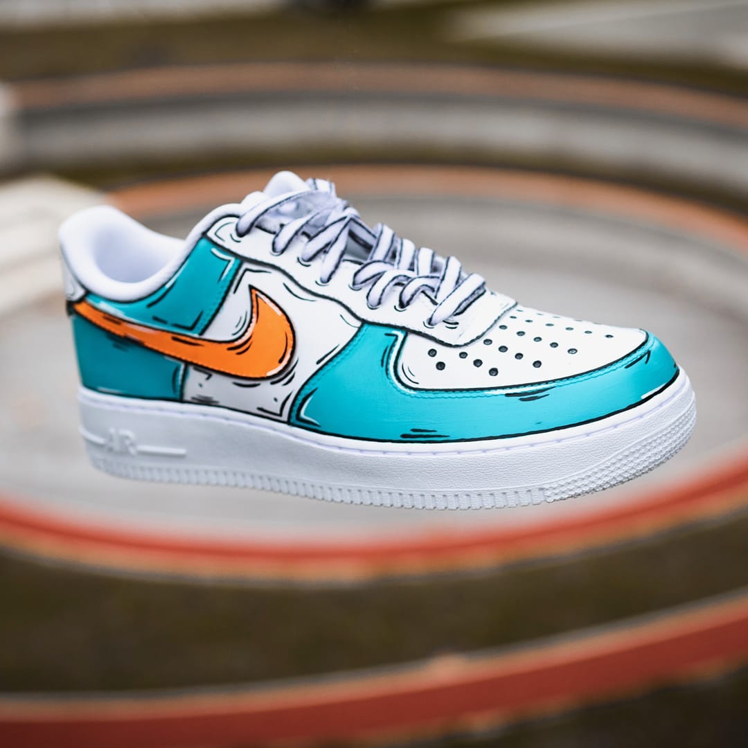 Playful custom Air Force 1 sneakers with contrasting light blue panels and a striking orange Nike swoosh, detailed with cartoon art.