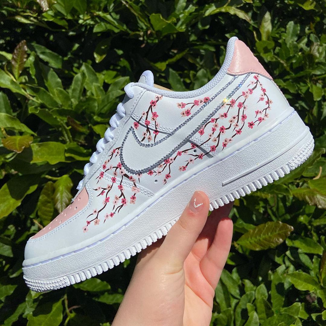 Custom Nike Air Force 1 shoes with an intricate cherry blossom pattern and soft pink accents, crafted for a fresh, nature-inspired look.