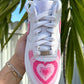 Top view of a custom Nike Air Force 1 sneaker, showcasing a pink heart design on the toe box with layered pink shades