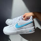 a pair of nike air force 1s with a simple blue hand-painted nike logo and sole design on the side of the sneakers. Blank gray shadow wall on the background