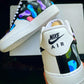 Custom Nike Air Force 1 sneakers with a black and white base featuring a colorful camo design on the back, blending shades like blue, pink, and green.
