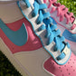 Zoomed-in shot of custom Nike Air Force 1 showing blue laces on one shoe and pink on the other, with contrasting pink and blue panels.