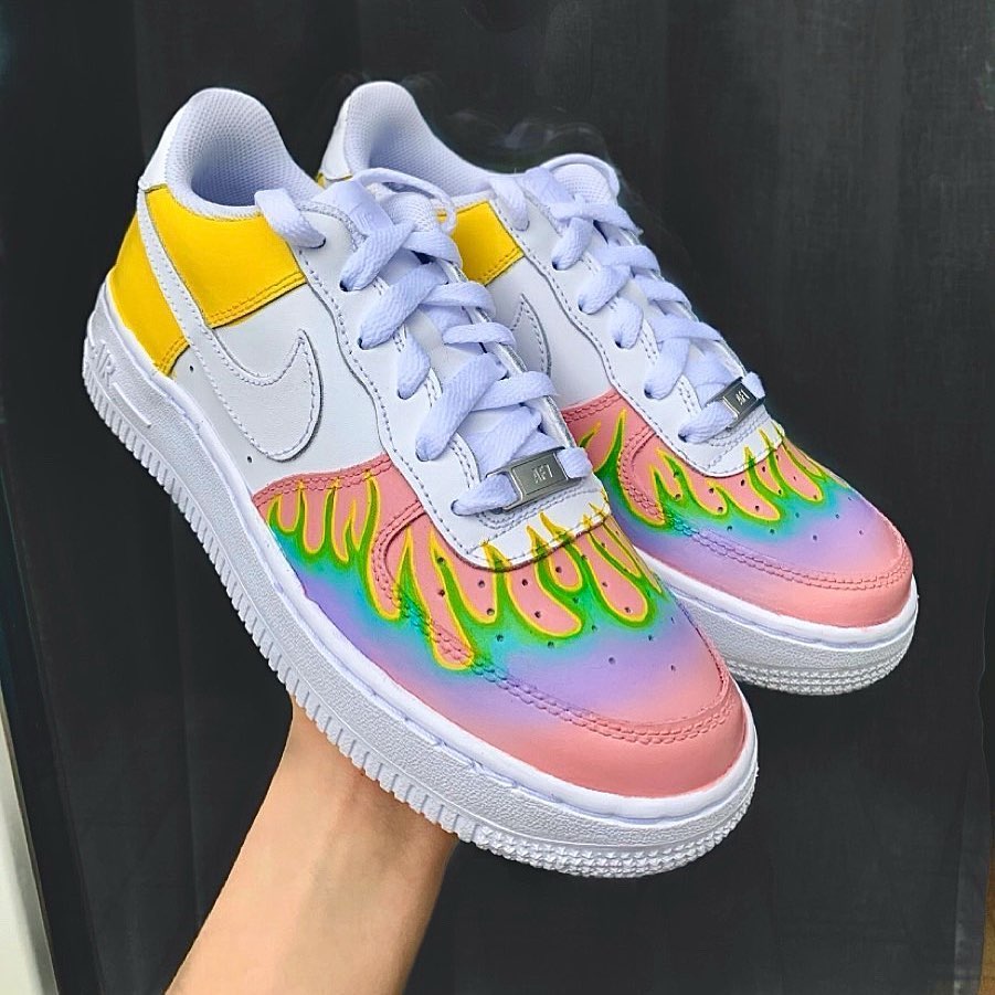 Custom Nike Air Force 1 sneakers with a vibrant rainbow flame design on the toe box, transitioning from pink to green and blue, and yellow accents on the heel.