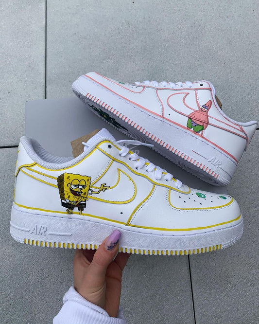 Custom Nike Air Force 1 sneaker featuring a hand-painted Spongebob Squarepants on the side with yellow accents outlining the Swoosh and detailing.