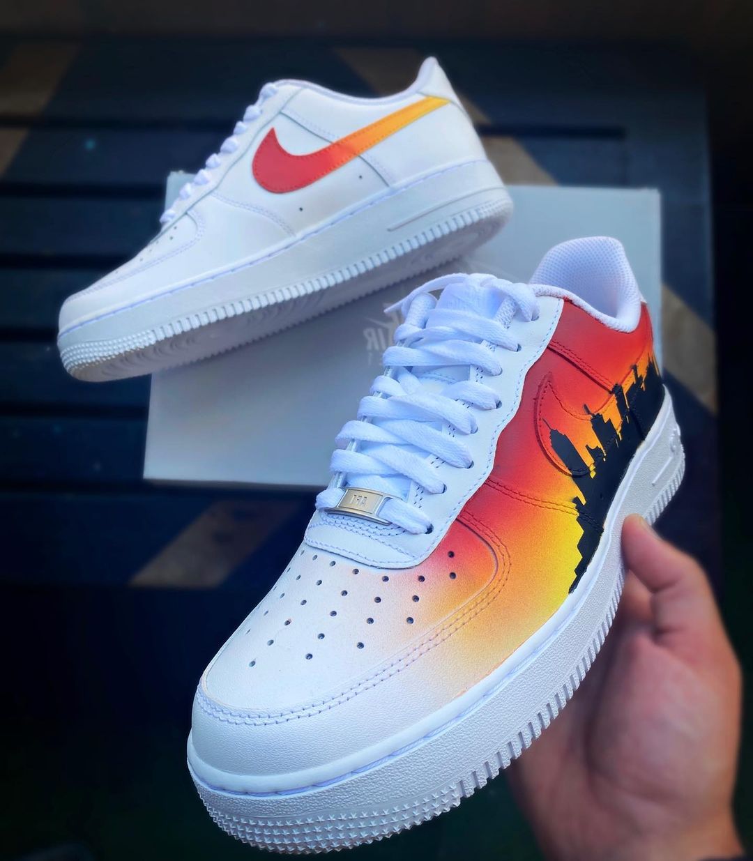 Custom Nike Air Force 1 with a bold orange-to-yellow fade and city skyline silhouette painted on the side.
