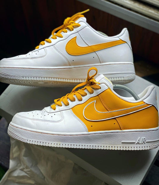 Custom Nike Air Force 1 sneakers with a bright yellow Swoosh and yellow accents on the side panel, complemented by matching yellow laces.