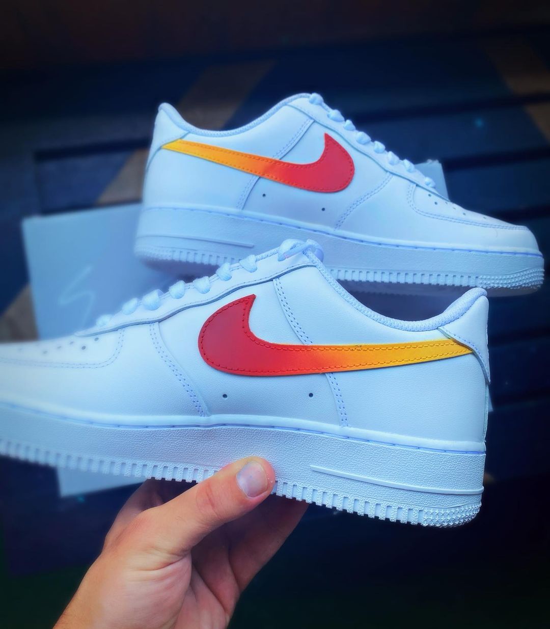 Close-up of Nike Air Force 1 with a red and yellow gradient Swoosh which is handpainted on the sides of sneakers