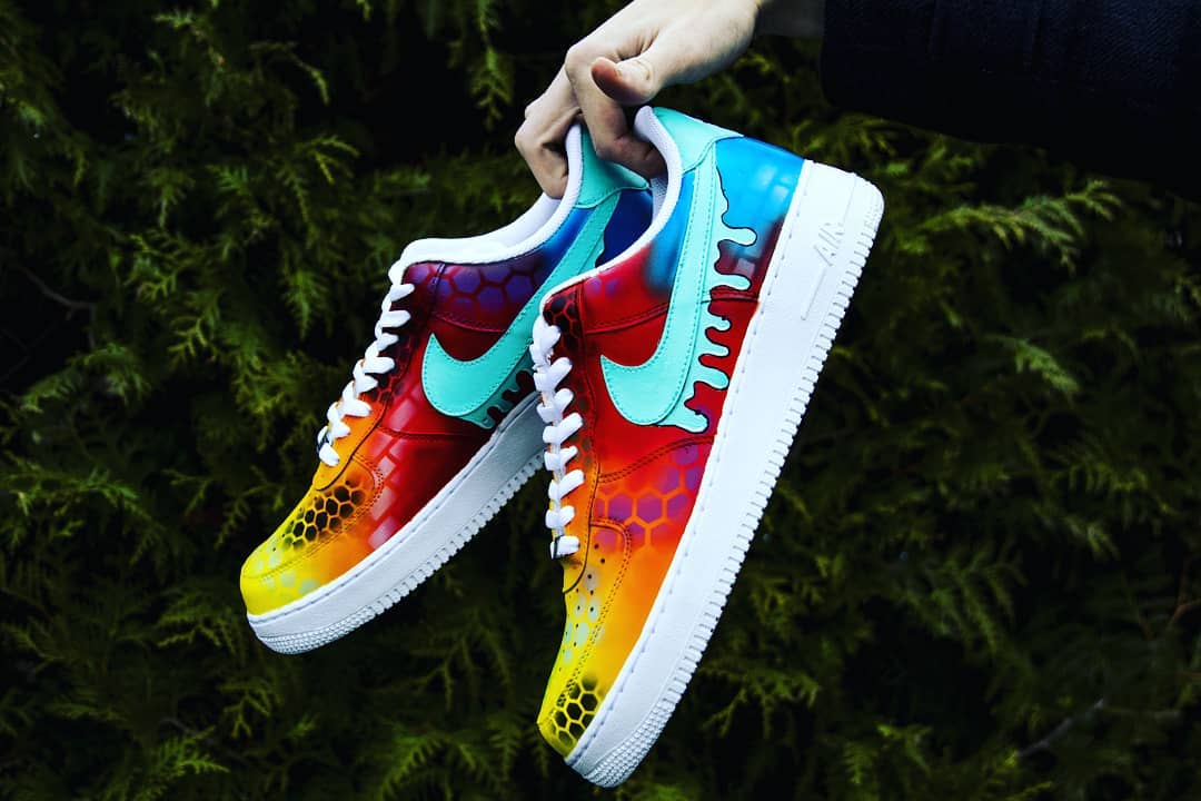 Hand-painted custom Air Force 1 shoes with a multicolored fade, intricate hexed designs, and a unique dripping blue Nike swoosh.