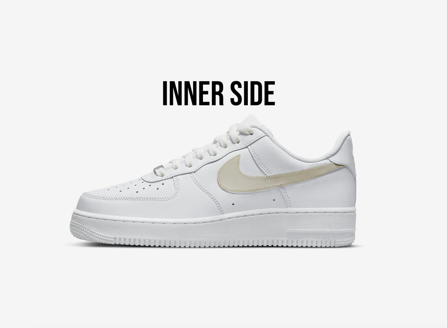 inner side view of white nike air force 1s with a beige swoosh, white background