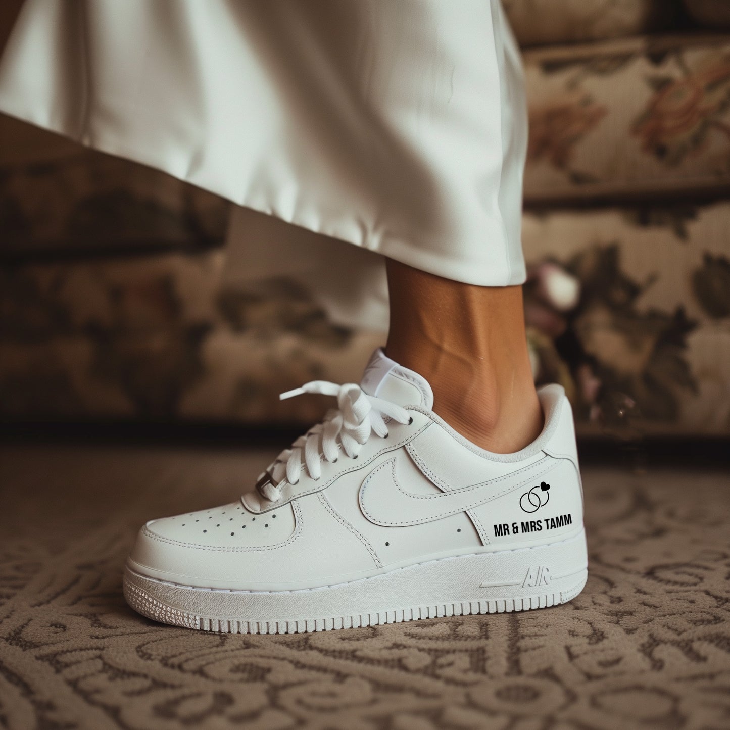 woman in white dress wearing nike air force 1 sneaker with a handpainted ring and letter mr & mrs tamm on the side of the sneaker in black