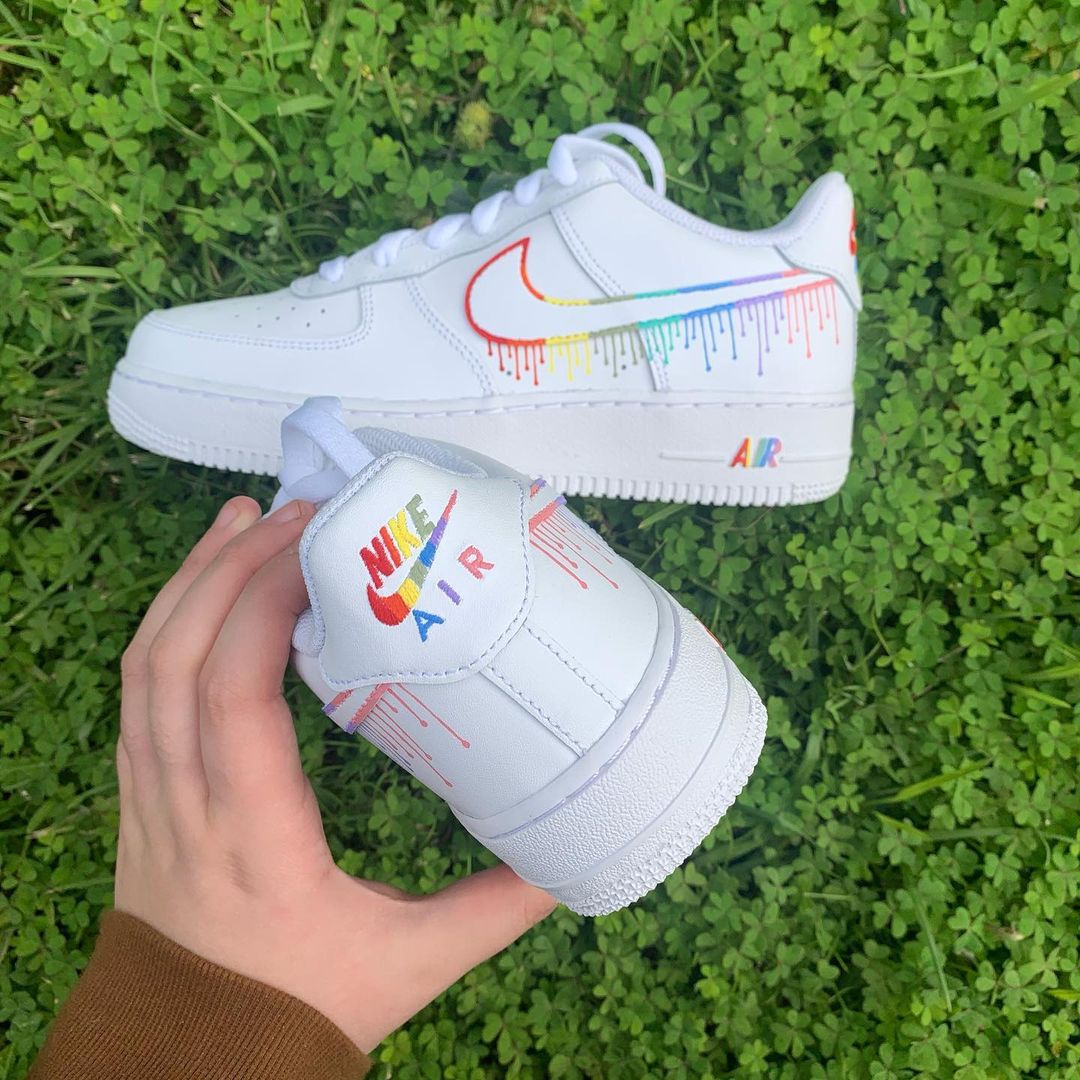 pair of nike air force 1s with a colorful dripping design on the nike swoosh and on the back heel panel. Grass background