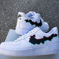 a pair of custom black glitch logo design air force 1 sneakers on a street background