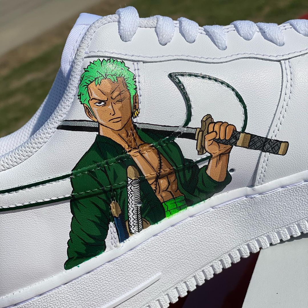 Close-up of custom Air Force 1 sneakers with an anime-inspired character holding a sword, showcasing detailed handpainted artwork.