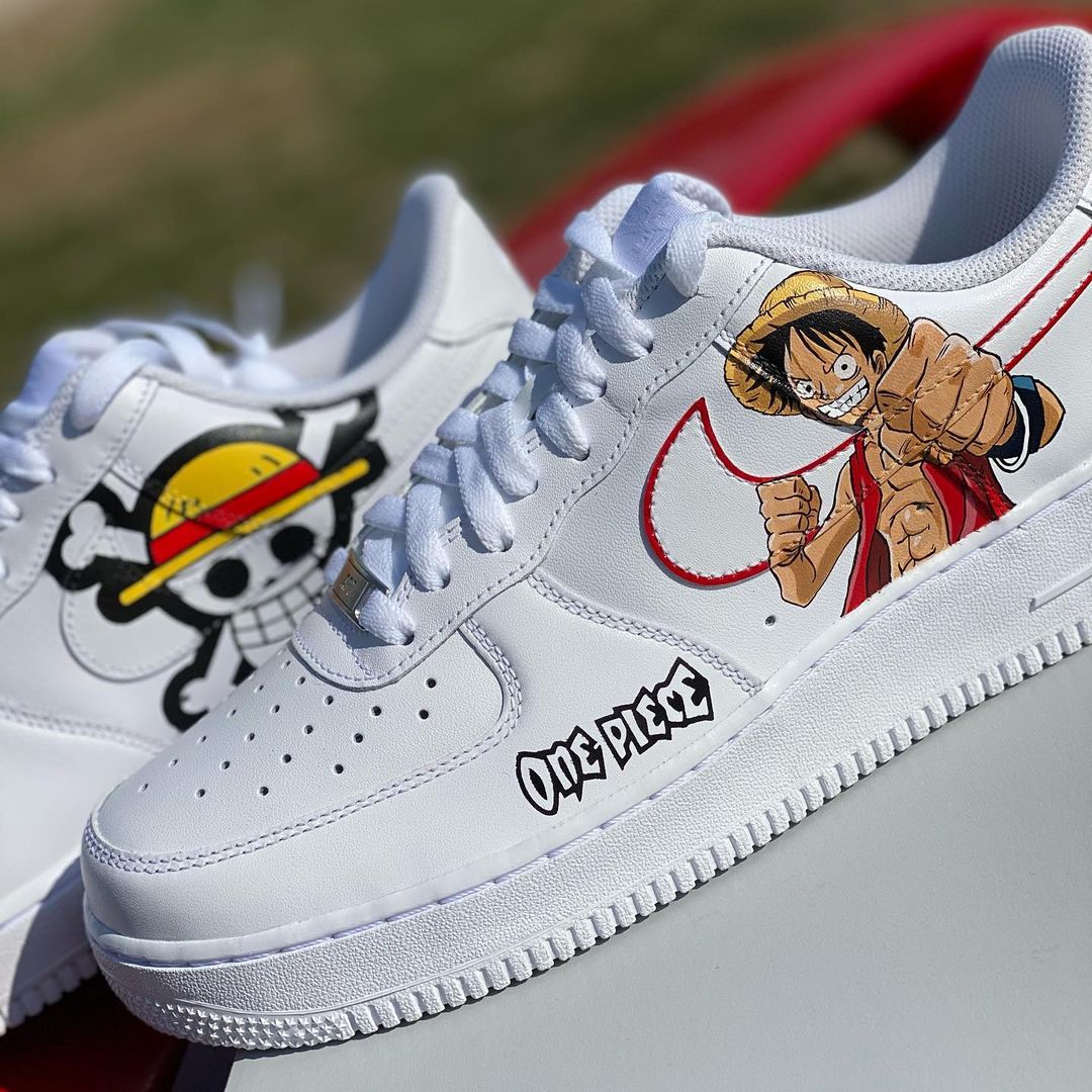 Custom Air Force 1 sneakers depicting a famous anime character with a straw hat, bold red swoosh, and the “One Piece” logo, capturing a unique design.