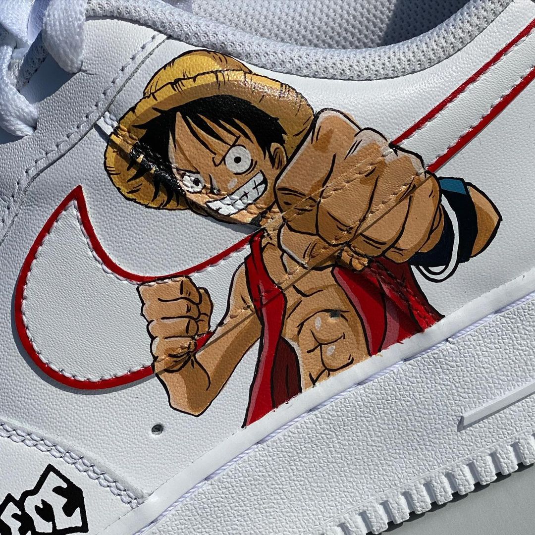Close-up of anime character in straw hat on custom Air Force 1, with vibrant handpainted details and red swoosh.