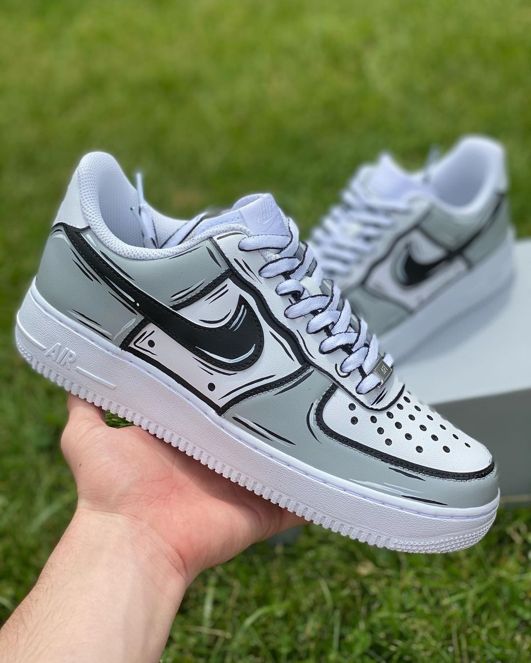 Custom Nike Air Force 1 sneakers with a handpainted gray and black outline design, giving them a bold, comic book-inspired look.