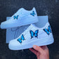 Side view of custom Nike Air Force 1 showcasing multiple blue butterflies on a clean white background.