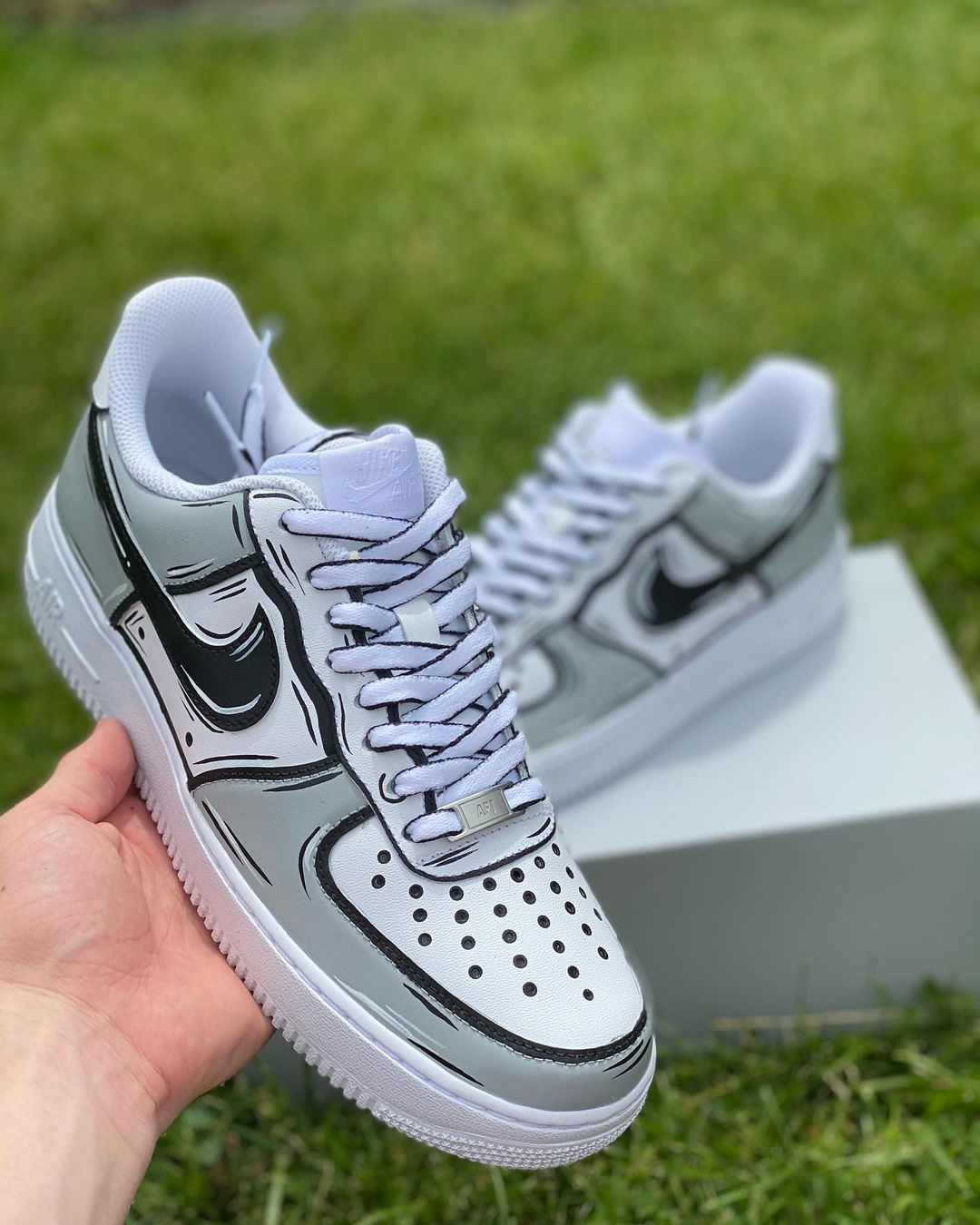Close-up of custom Air Force 1 sneakers featuring a handpainted black and white comic-style outline for a unique visual effect.