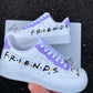 Custom Nike Air Force 1 sneakers inspired by the TV show Friends, with “F.R.I.E.N.D.S” text and purple accents.