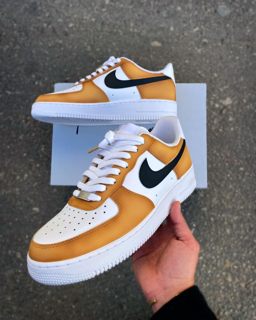 Custom Nike Air Force 1 sneakers with a mustard yellow and white colorway, featuring a bold black swoosh.