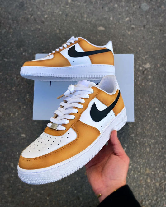Custom Nike Air Force 1 sneakers with a mustard yellow and white colorway, featuring a bold black swoosh.