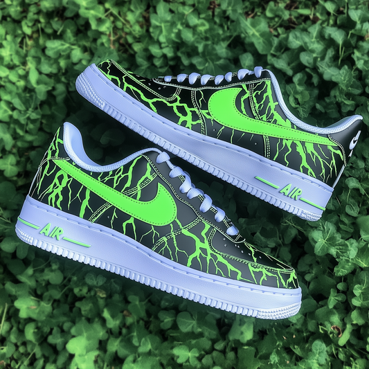 Close-up of custom Nike Air Force 1 sneakers with a neon green lightning design on a green leaf background.