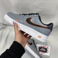 Close-up of custom Nike Air Force 1 sneakers featuring a bold gray-and-orange outline effect on a sleek leather base