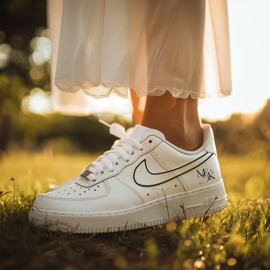 bride wearing white nike air force 1s with a handpainted black outline nike swoosh and initials on the back heel. Summer vibe. 