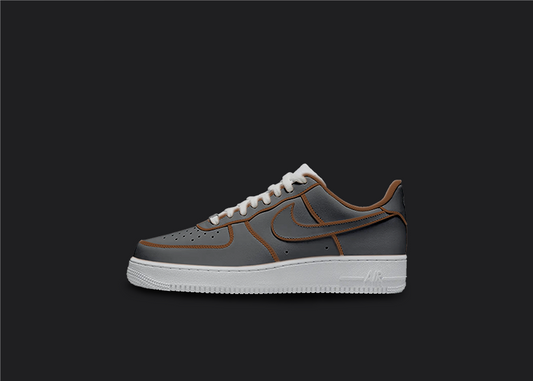 The image is featuring a Custom cartoon Air force 1 sneakers on a blank black background. The white nike sneaker has a black and brown design on the entire air force sneaker. 