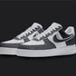 The image is of a Custom Nike Air force 1 sneaker pair on a blank black background. The white custom sneakers have a black cartoon styled design. 