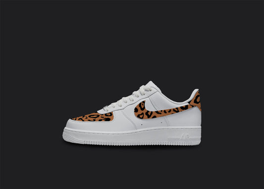 The image is of a Custom Nike Air force 1 sneaker on a blank black background. The white custom sneaker has a Cheetah print in the front and on the nike logo. 