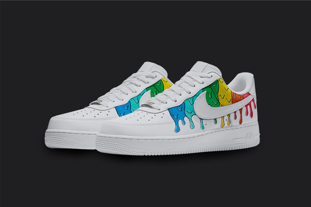 The image is of a Custom Nike Air force 1 sneaker pair on a blank black background. The white custom sneakers have a colorful dripping design which starts from the top of the sneakers. 