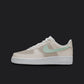 The image is of a Custom Nike Air force 1 sneaker on a blank black background. The white custom sneaker has a creme tone and a mint colored nike logo.