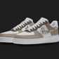 The image is of a Custom Nike Air force 1 sneaker pair on a blank black background. The custom sneaker pair has a dior pattern design on the nike logo and brown tones all over the sneakers.