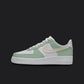 The image is of a Custom Nike Air force 1 sneaker on a blank black background. The white custom sneaker has a Green and beige pastel colorway design.