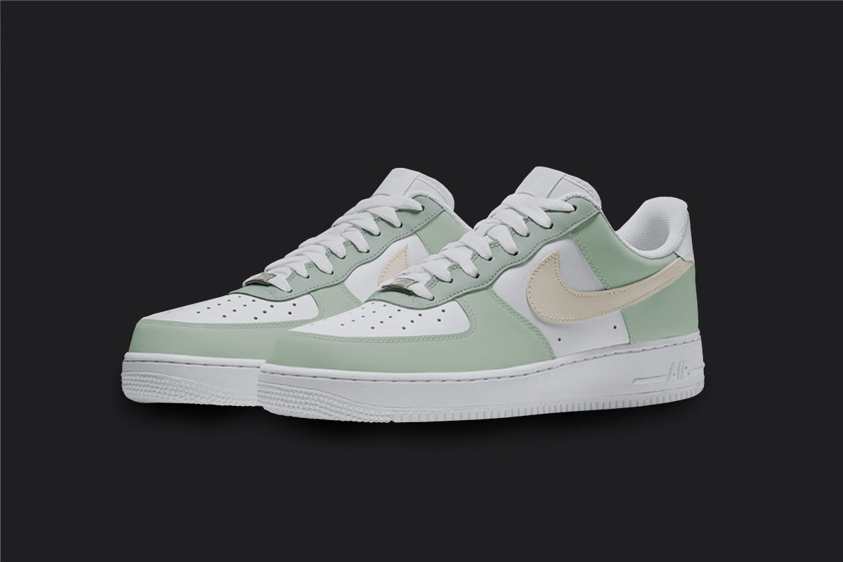The image is of a Custom Nike Air force 1 sneaker pair on a blank black background. The white custom sneakers have a pastel green and beige colorway covering the nike sneakers.