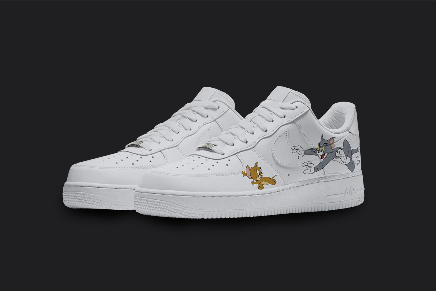 The image is of a Custom Nike Air force 1 sneaker pair on a blank black background. The white custom sneakers have a tom and jerry design on the outside of the shoes. 