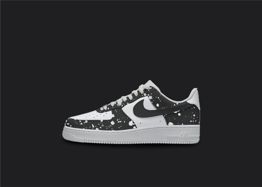 Custom Nike air force 1s are displayed on a dark blank background. The sneakers feature a black custom design with white splatter all over the sneakers.