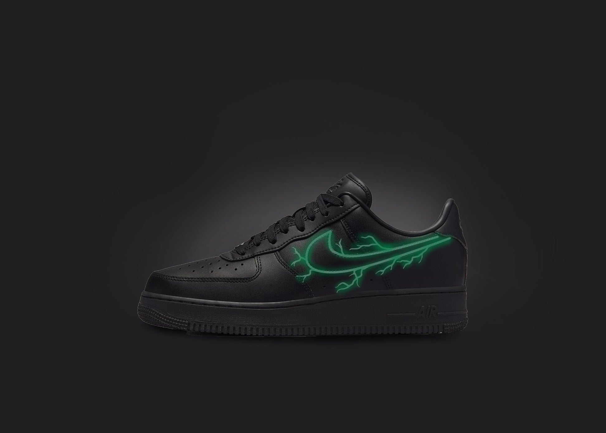 The image is featuring a custom black Air force 1 sneaker on a blank black background. The black nike sneaker has a green lightning design on the nike logo. 