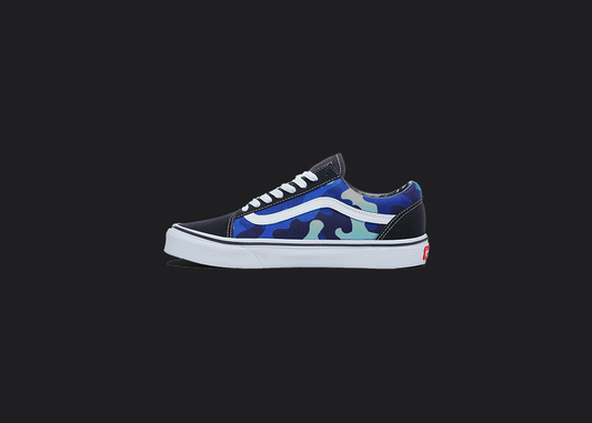 The image is featuring a custom hand painted vans shoes on a blank black background. The vans old skools sneaker has a custom blue camo design on the side of shoes. 
