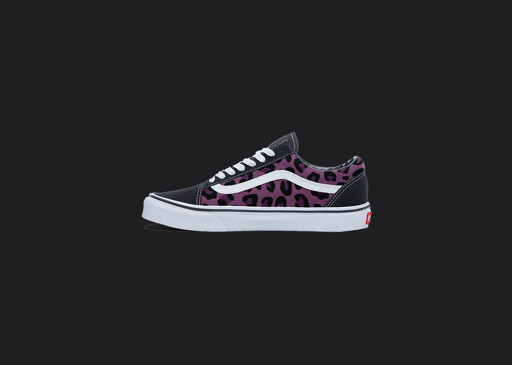 The image is featuring a custom hand painted cheetah print vans shoes on a blank black background. The vans old skools sneaker has a pink cheetah print design on the side of shoes.