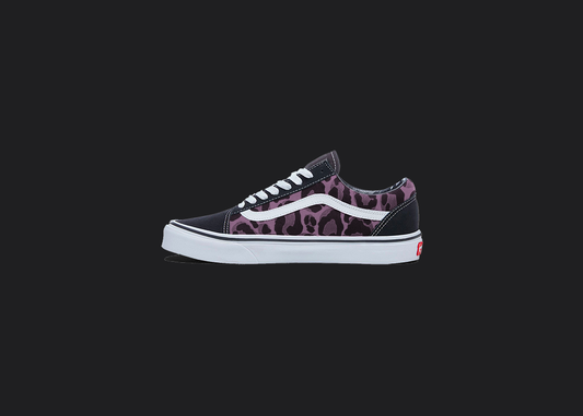 The image is featuring a custom hand painted leopard print vans shoes on a blank black background. The vans old skools sneaker has a pink leopard print design on the side of shoes. 