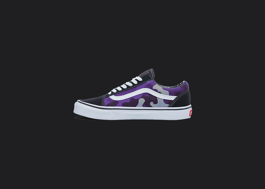 The image is featuring a custom hand painted vans shoes on a blank black background. The vans old skools sneaker has a custom purple camo design on the side of shoes. 
