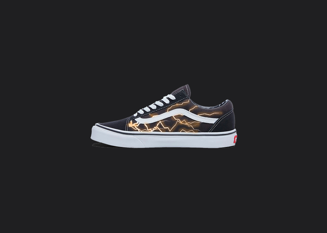 The image is featuring a custom hand painted vans shoes on a blank black background. The vans old skools sneaker has a custom orange lightning design on the side of shoes. 