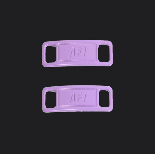 The image is featuring a pair of purple shoe tags on a blank black background. The air force 1 shoes tags are for sneaker laces and come in pairs. 