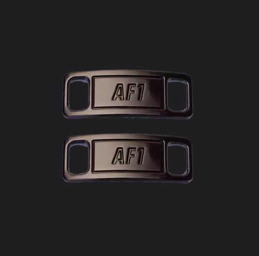 The image is featuring a pair of black shoe tags on a blank black background. The air force 1 shoes tags are for sneaker laces and come in pairs. 